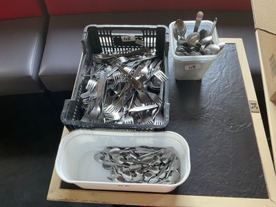 un plateau de couverts posé sur une table à côté d'un récipient contenant des couverts