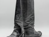 une paire de bottes en cuir noir sur fond blanc