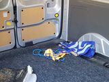 the interior of a van with the door open and the floor covered in blue carpet