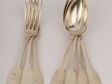 two spoons and a fork are sitting on a white surface