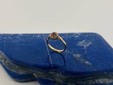 une image d'une bague en diamant posée sur une pierre bleue