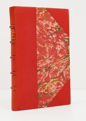 un vieux livre à la couverture rouge, orné d'un motif
