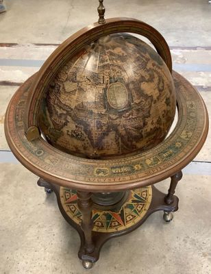 un vieux globe terrestre posé sur un socle dans une pièce