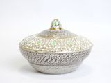 a white and green bowl with a lid on a white surface