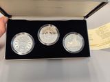two silver coins in a box with a hand holding one of them