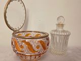 a glass bowl with a mirror and a glass jar on a table