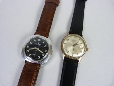 deux montres assises l'une à côté de l'autre sur une surface blanche