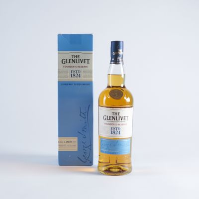 une bouteille de whisky single malt The Glenlivet à côté d'une boîte bleue