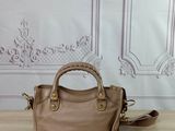 a brown handbag sitting on top of a wooden table