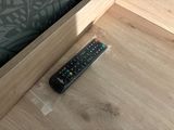 a remote control sitting on the floor next to a bed