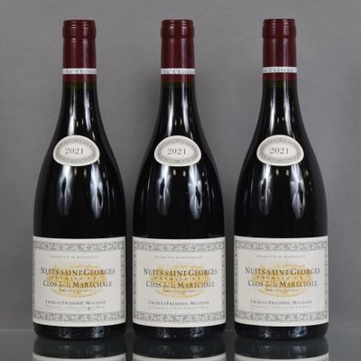 three bottles of red wine sit on a table in front of a gray background
