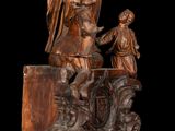 statue of a man holding a cross with a woman and a child
