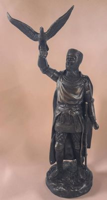 bronze statue of a man holding a bird and a bird perched on his arm