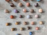a lot of different colored marbles on the floor