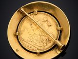a close up of a gold coin with a stick in it