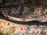 a person holding a purse that has a floral pattern on it