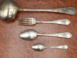 five silver spoons and two silver spoons on the table