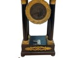a black and gold clock with a gold medallion on top of it