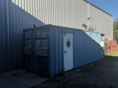 un conteneur d'expédition bleu posé devant un immeuble