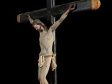 statue of jesus on a cross with a black background
