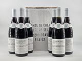trois bouteilles de vin rouge sont posées devant une boîte blanche