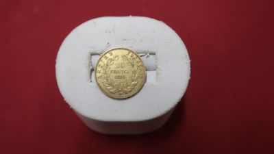 a gold coin sitting on top of a white box