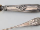 two spoons and a fork on a white surface