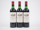 trois bouteilles de vin rouge posées l'une à côté de l'autre sur une surface blanche