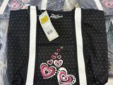 a black bag with hearts on it sitting on a bed