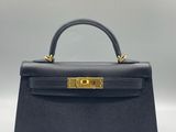 un sac à main en cuir bleu avec des finitions dorées sur la poignée