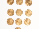 plusieurs pièces d'or disposées en forme de cœur sur une surface blanche