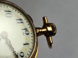 a close up of a gold pocket watch with roman numerals on the face