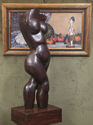 une statue représentant une femme debout sur un socle en bois