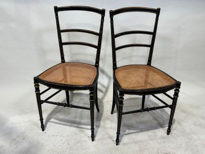 deux chaises noires avec des assises en osier, sur fond blanc