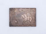 an image of a metal plaque depicting a man riding a horse