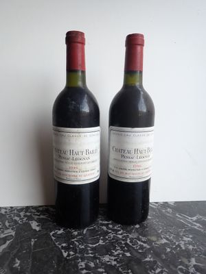 two bottles of red wine sitting on a table