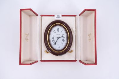 une horloge qui se trouve dans une boîte posée sur une surface blanche