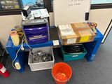 a desk with a lot of boxes and a bucket on it