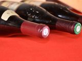several bottles of wine are lined up on a red table