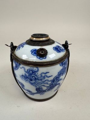 un vase bleu et blanc posé sur une surface blanche