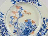 an image of a blue and white plate with a bird and flowers on it