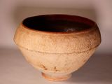 a brown and black bowl sitting on a white surface