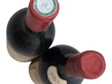 two bottles of wine sitting next to each other on a table