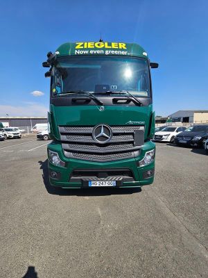 un camion vert garé sur un parking