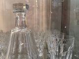 bottles and glasses on a glass shelf in a glass case