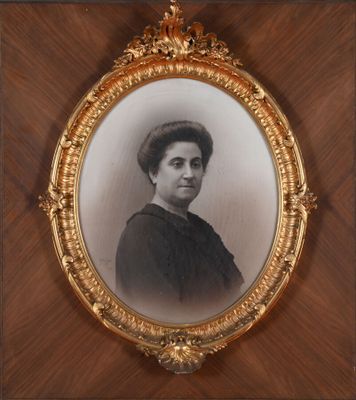 an old photo of a woman in a black dress in a gold frame