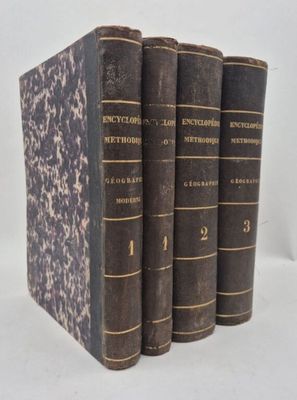 three old books sitting on top of each other on a white surface