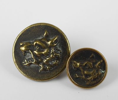 a pair of brass buttons with a dog on them
