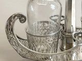 a silver plate with a glass bottle and a candle holder on it