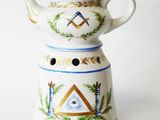 une théière blanche ornée d'un motif bleu et or